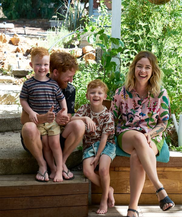 Nici, Ben and their two children sitting on decking in the garden.