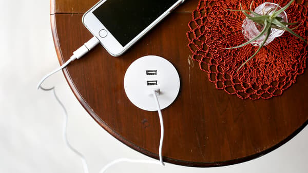 NORDMÄRKE 노르드메르케 USB 충전기가 나무의 둥근 홈에 끼워져 있고 케이블을 사용해 휴대폰을 충전기에 연결했어요.