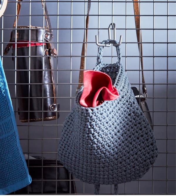 NORDRANA baskets hanging on a wire mesh room divider.