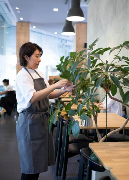植物の世話をしているウエイトレス