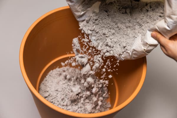 Nun wird ein wenig Sand in den Tontopf gefüllt.