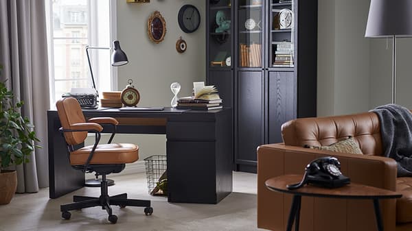 oficina en una casa, con un escruitorio negro con silla cafe que combina a la perfección