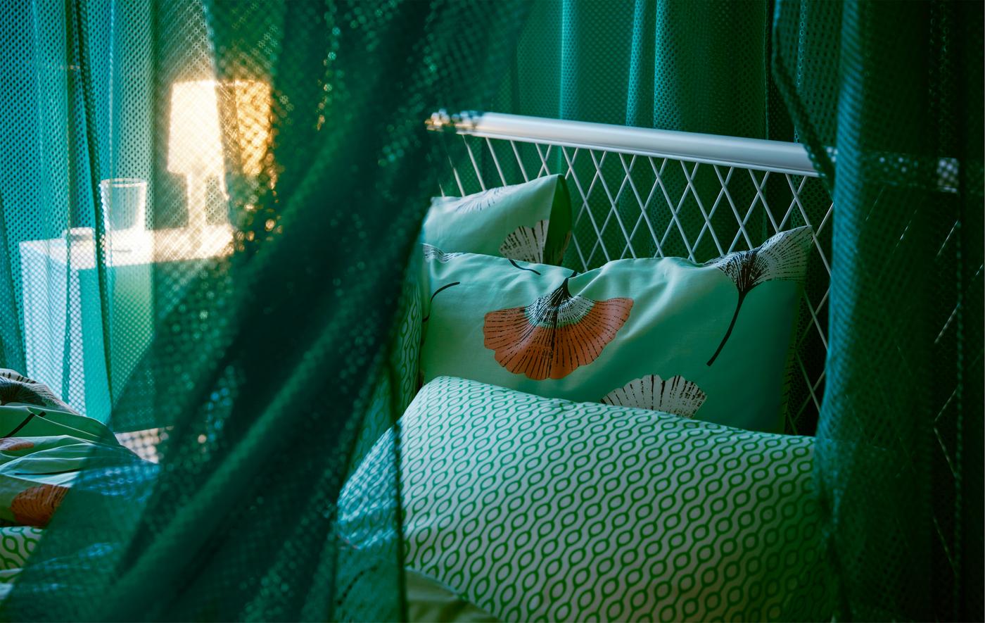 Okačene zelene IKEA GRÅTISTEL mrežaste zavese stvaraju prostoriju unutar prostorije, istovremeno propuštajući malo svetlosti.