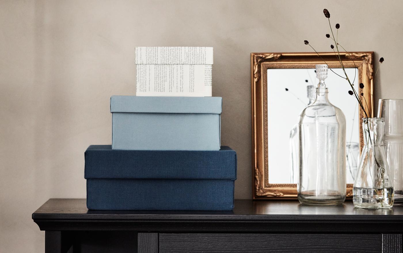 Old shoeboxes turned into new, display-worthy storage boxes after being covered with fabric and old book pages