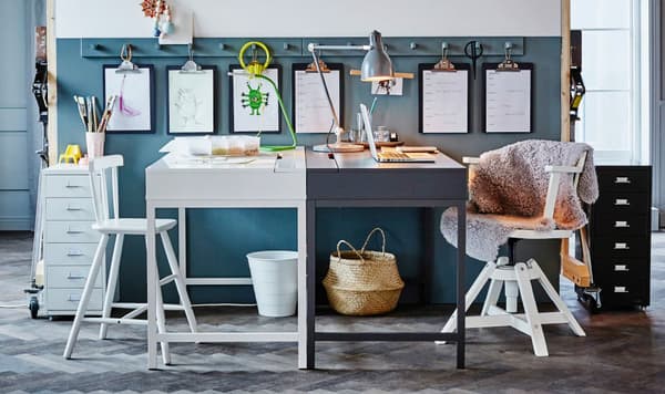 One white desk and one dark grey desk facing each other to create two different work stations