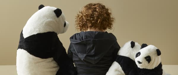 Otrok in plišaste igače - medvedi panda.