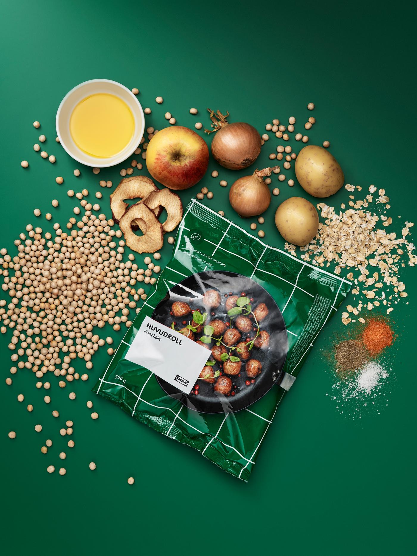 Package of HUVUDROLL plant balls, surrounded by the unprocessed ingredients: peas, oats, potatoes, onions, apples, spices.