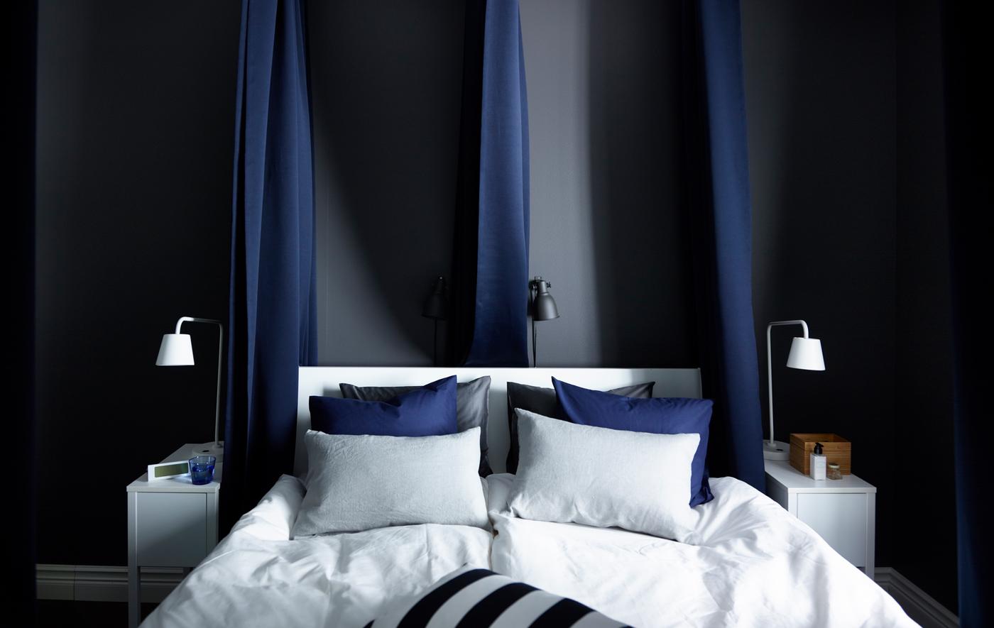 Padded, dark blue curtains hung around the outside and in between the bed help block out sound and light. Dark walls and crisp white sheets help create a feeling of calm.
