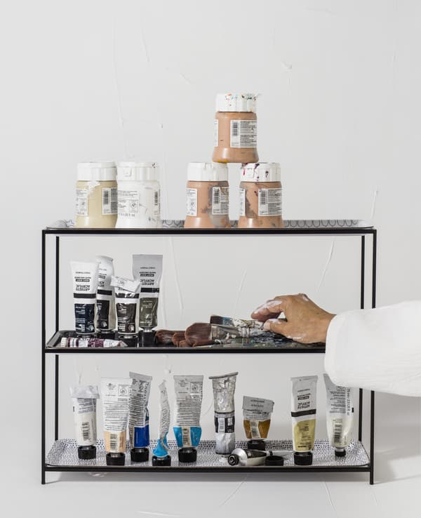 Paint tubes displayed on a black stand.