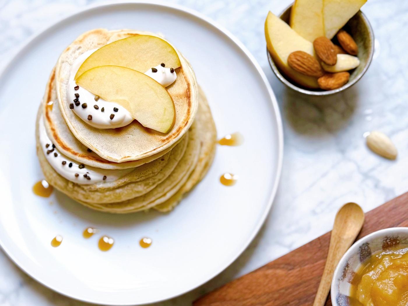 Pancakes mit Apfelmus auf einem Teller präsentiert.