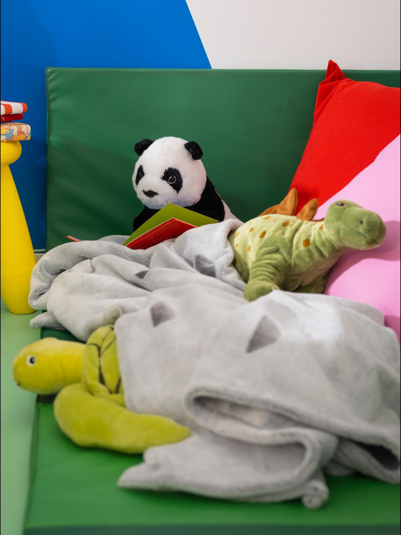 Panda toy on sofa with blankets