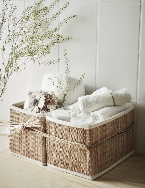 Panier détente à la salle de bain avec petites serviettes, bougies parfumées, pot-pourri et serviette.