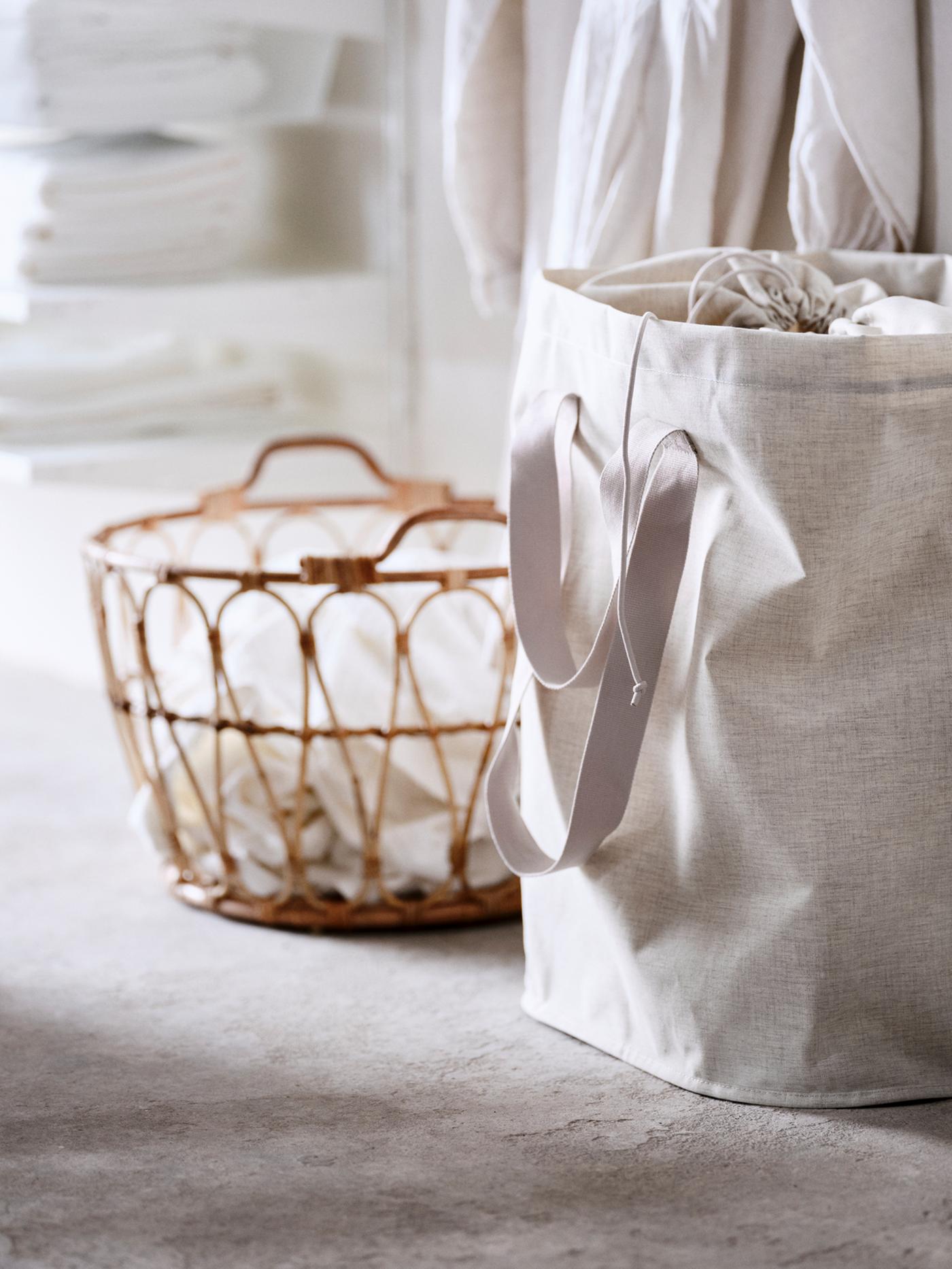 Panier SNIDAD contenant du linge et sac à linge PURRPINGLA au sol devant des tablettes contenant des serviettes pliées.