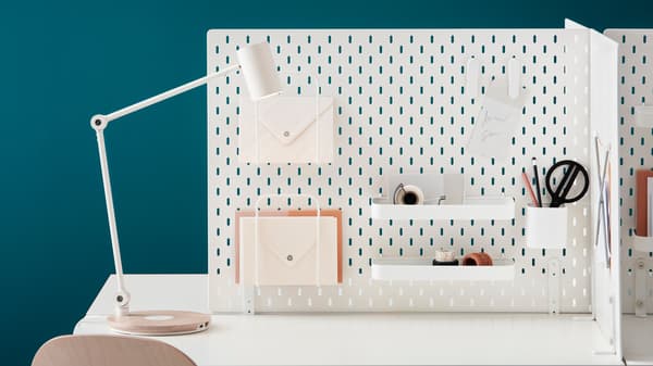 Panneau perforé sur le mur avec divers compartiments de rangement