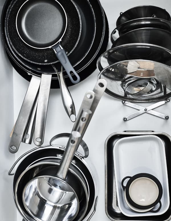 Pans and lids stacked in a drawer.
