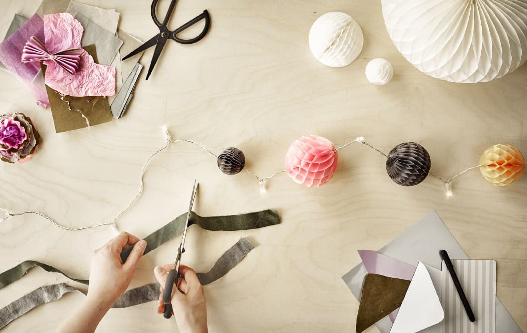 Paper materials laid out on table to make party decorations