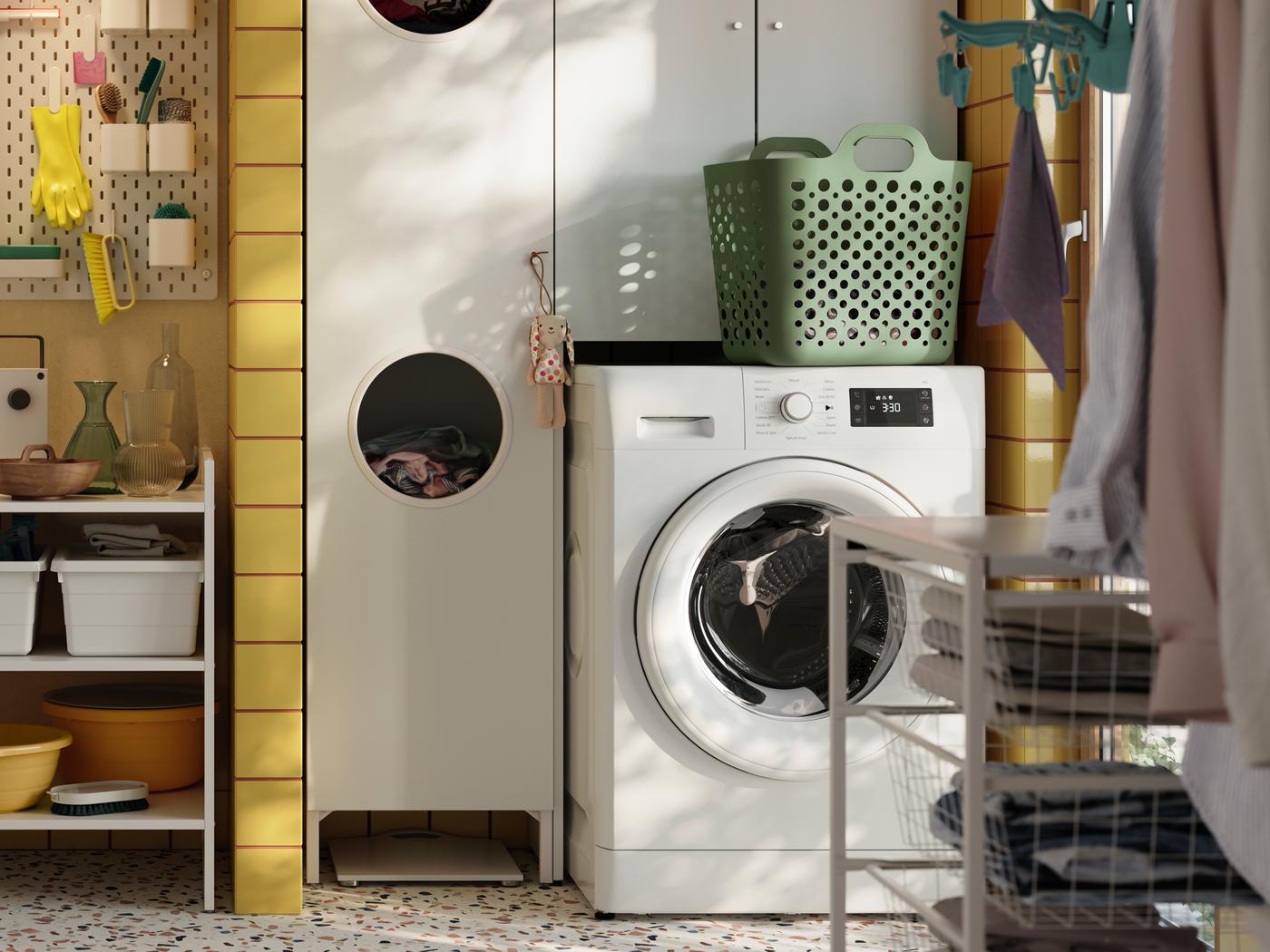 Part of a laundry room with a UDDARP washing machine, a NYSJÖN laundry cabinet and a JONAXEL shelving unit.