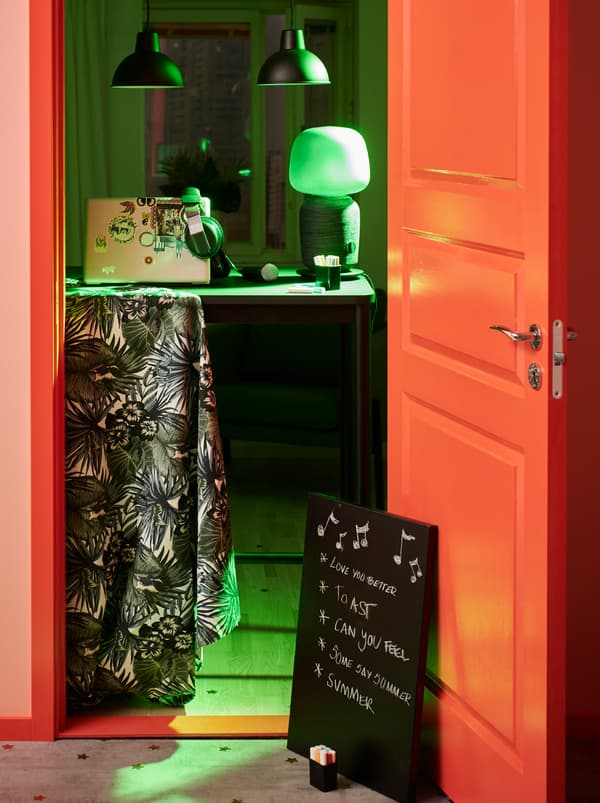 Party-lit room with DJ accessories on a TOMMARYD table across the doorway. A memo board on the floor lists musical wishes.