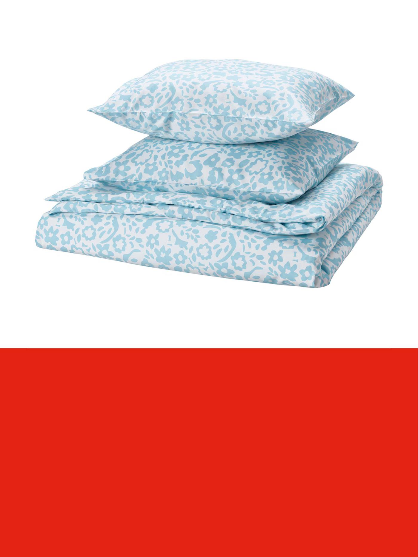 Parure de lit bleu clair à motif discret, composée d’une housse de couette et d’une taie d’oreiller, sur fond clair.