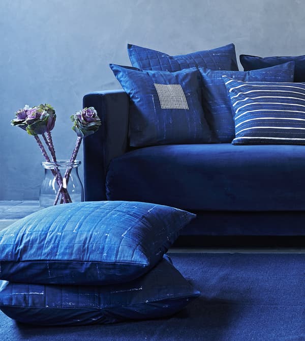 Patterned blue cushions on a blue sofa.