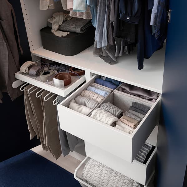 PAX wardrobe with white frame and pull=put trouser hanger. Other drawers and trays are pulled out slightly showing clothing items well sorted and organised. 