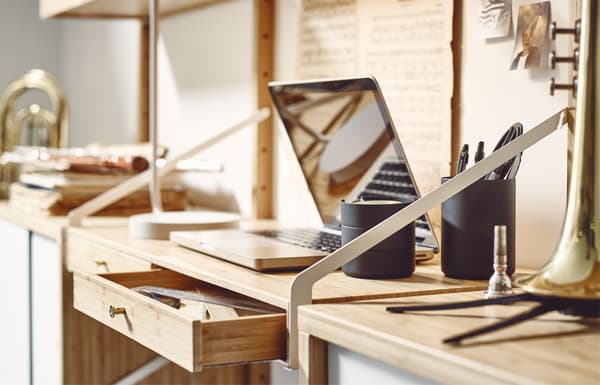 PC portable posé sur un bureau dans une étagère murale.