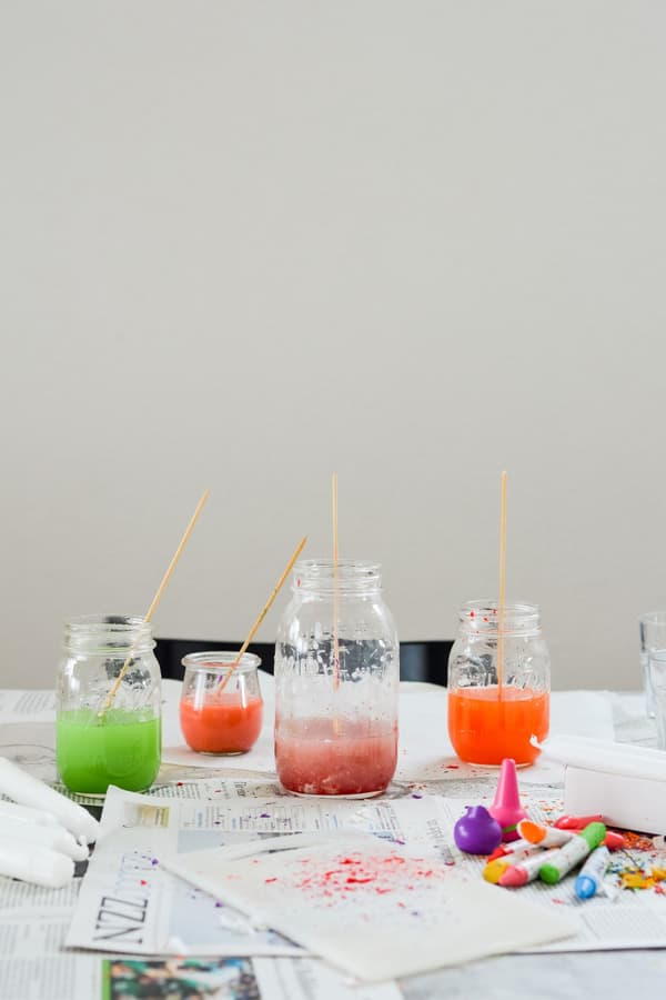 Peinture à la cire verte, orange et rose dans des récipients en verre, sur une table