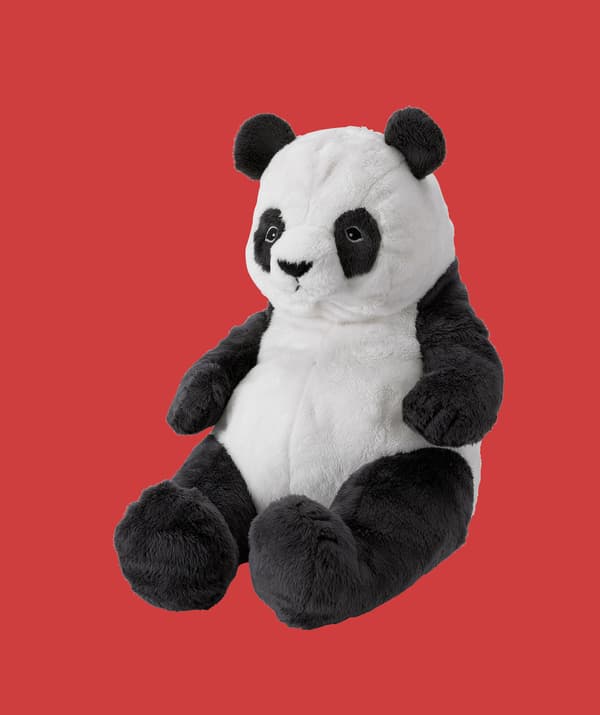 Peluche de panda sur fond rouge.