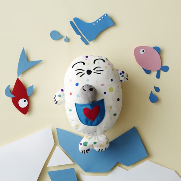 Peluche en forme de phoque coloré dans un décor de banquise en papier.