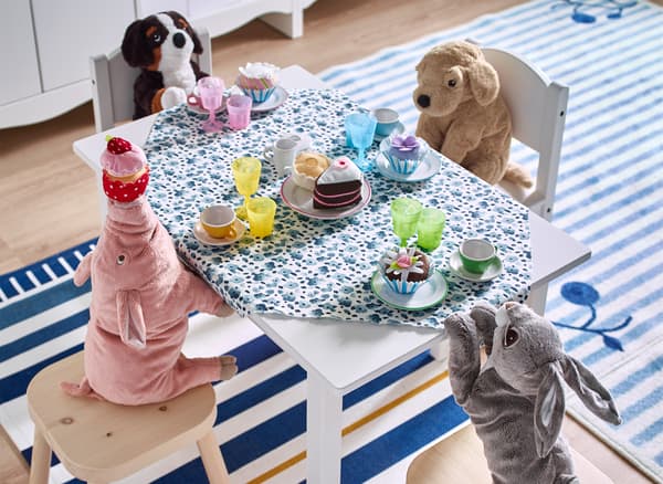 Peluches assises à une petite table, prêtes à prendre le thé.