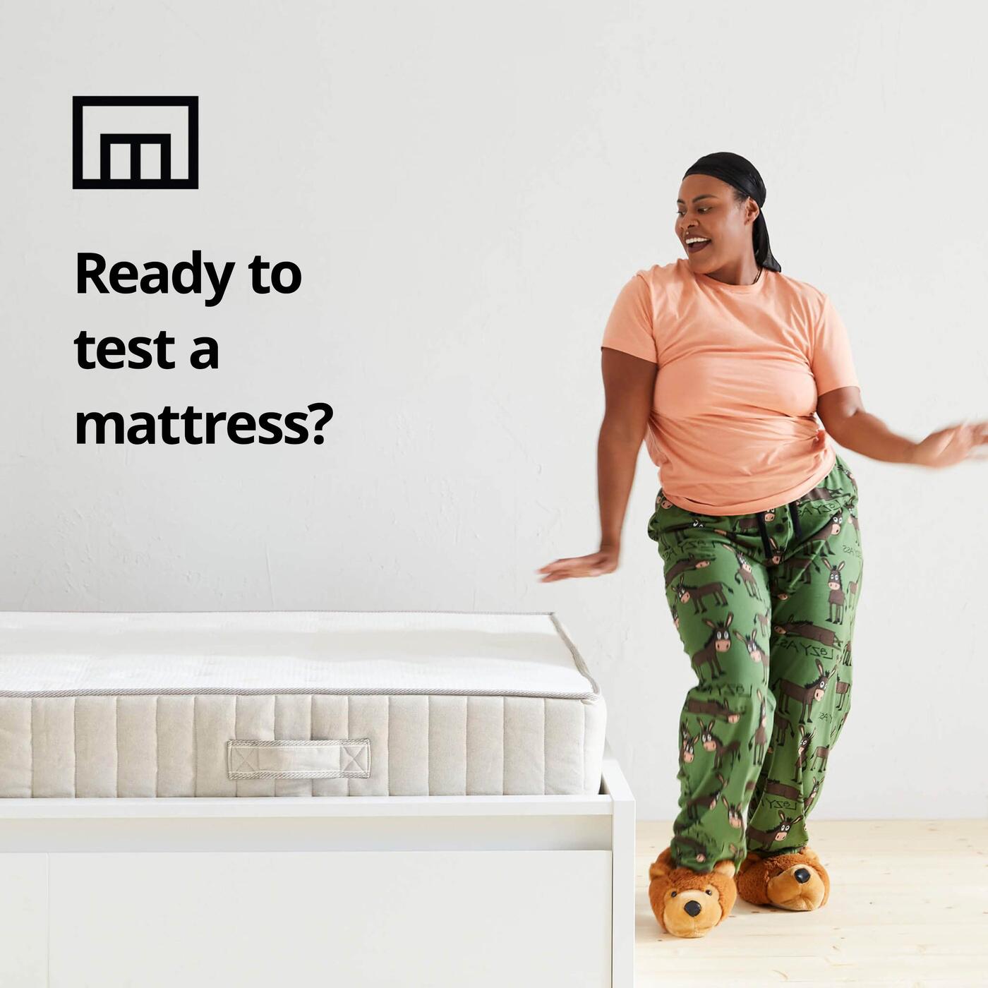 Person dancing next to bed with mattress; on left is text "Ready to test a mattress" with store-shaped symbol.