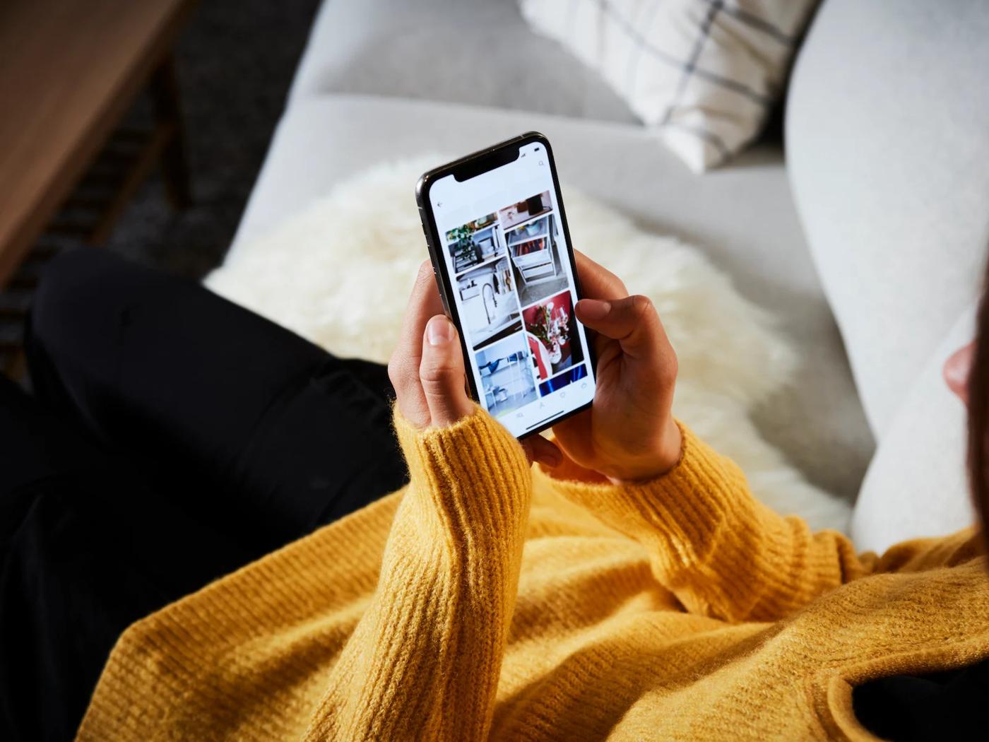 Person holding a cellphone, the screen shows the IKEA app