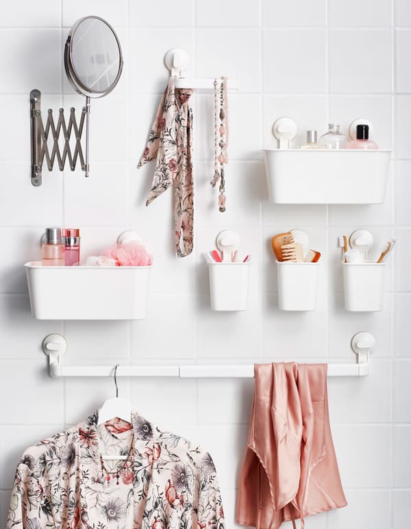 Petits récipients en plastique fixés par ventouse au mur de la salle de bain, comme rangements pour les articles de toilette et les accessoires.