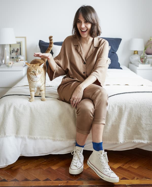 Photo de Carolina assise sur son lit avec son chat.