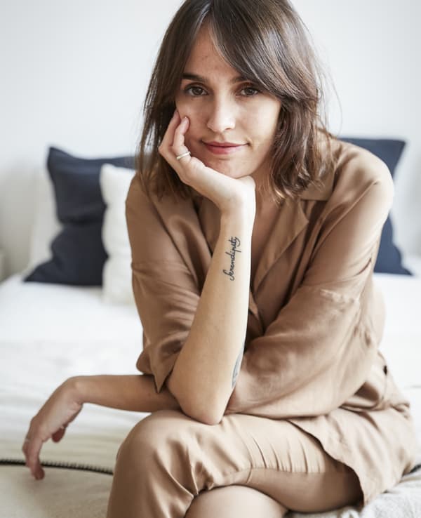 Photo de Carolina assise sur son lit.