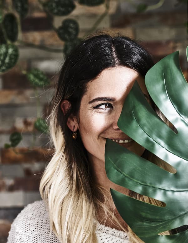 Photo de Miriam cachée derrière une feuille.
