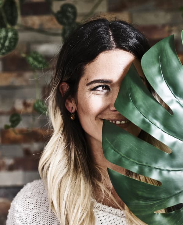 Photo de Miriam derrière une grande feuille.