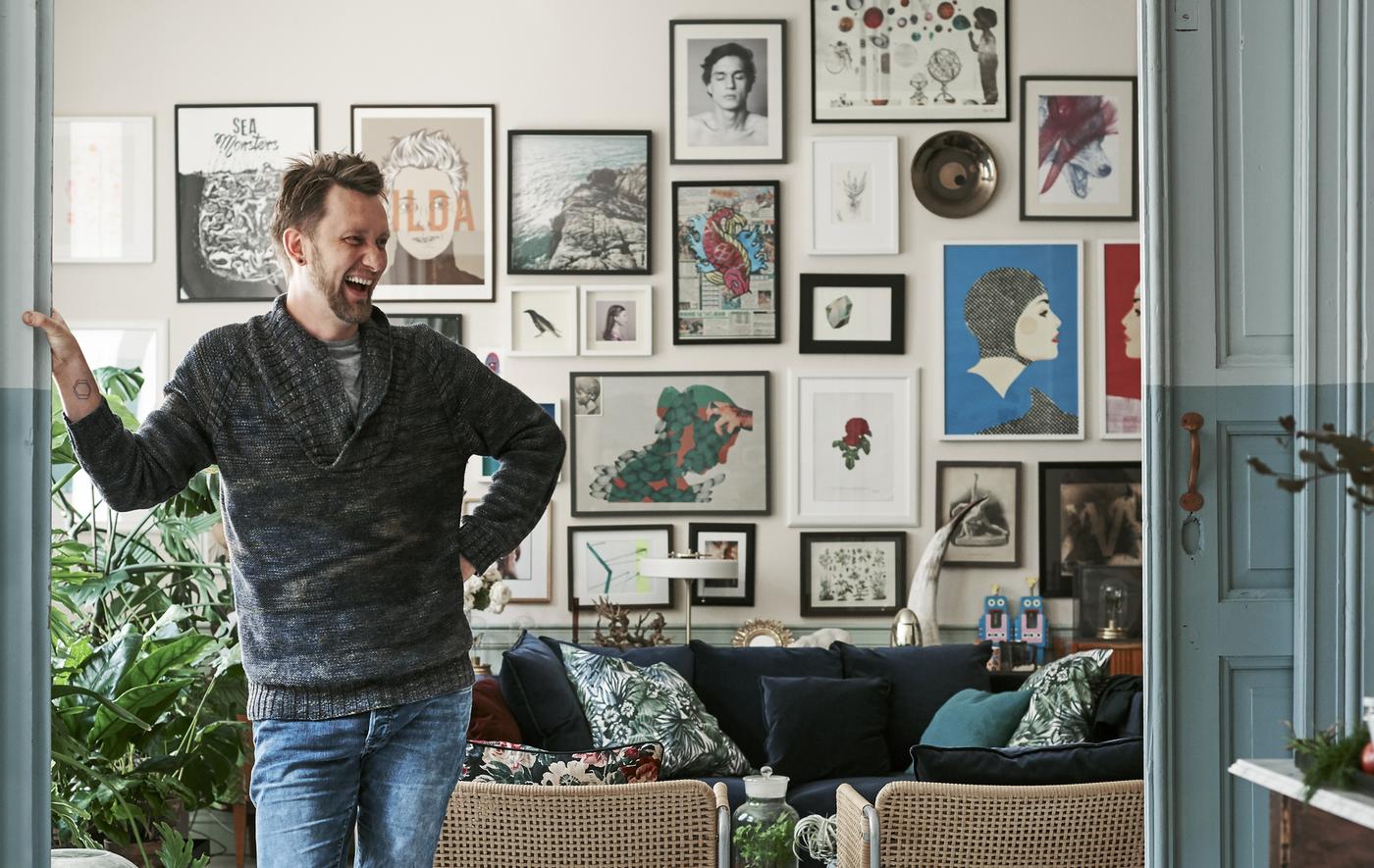 Photo de Radek debout devant un mur décoré de cadres.