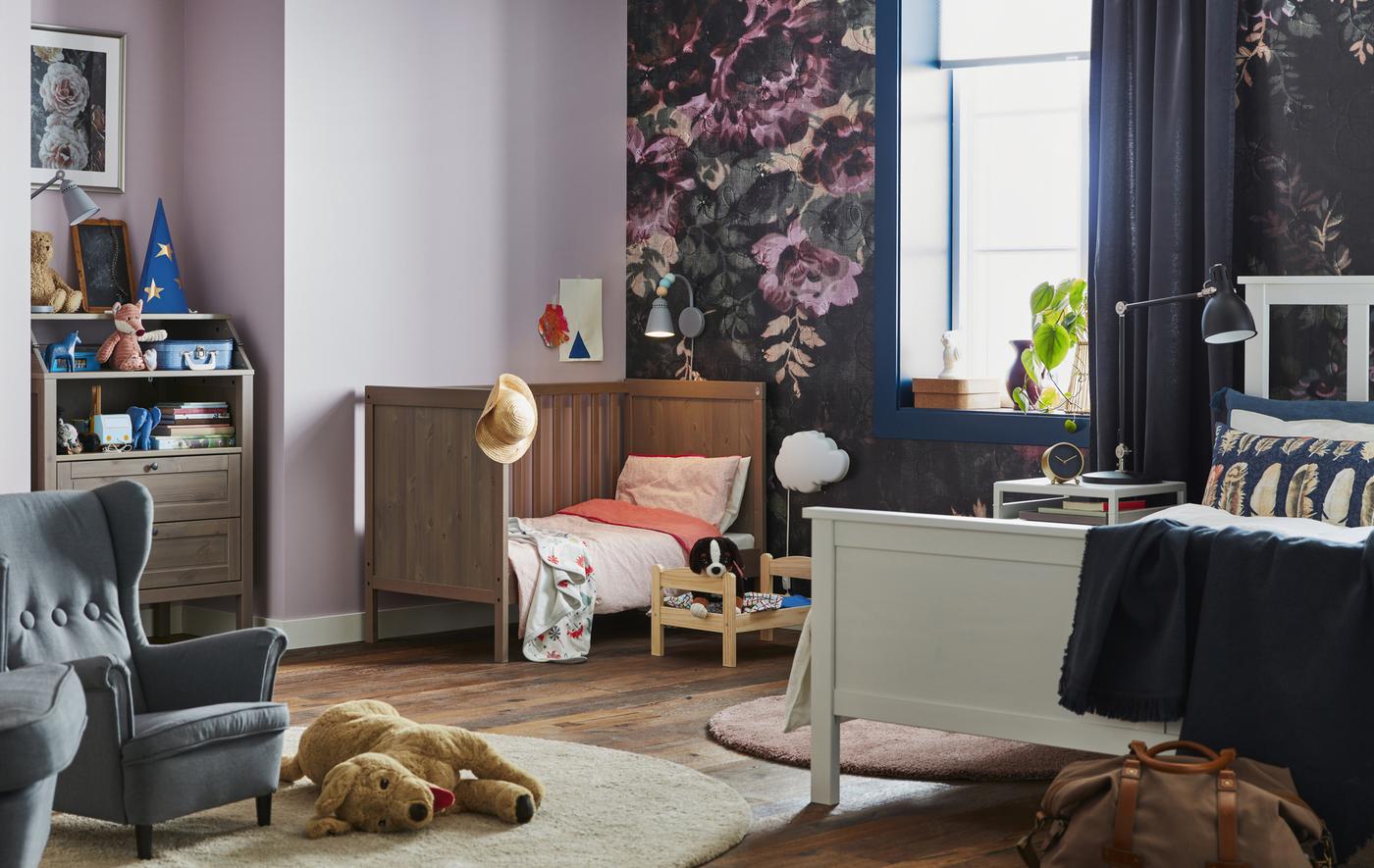 Photo d’une chambre à coucher avec lit double, lit bébé et jouets pour enfants.