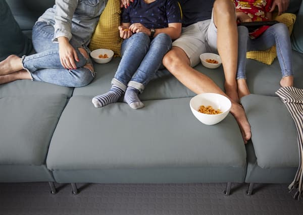 Pia’s family on a grey sofa in the playroom.