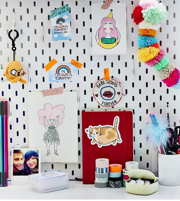 Pictures, badges and photos on a pegboard.