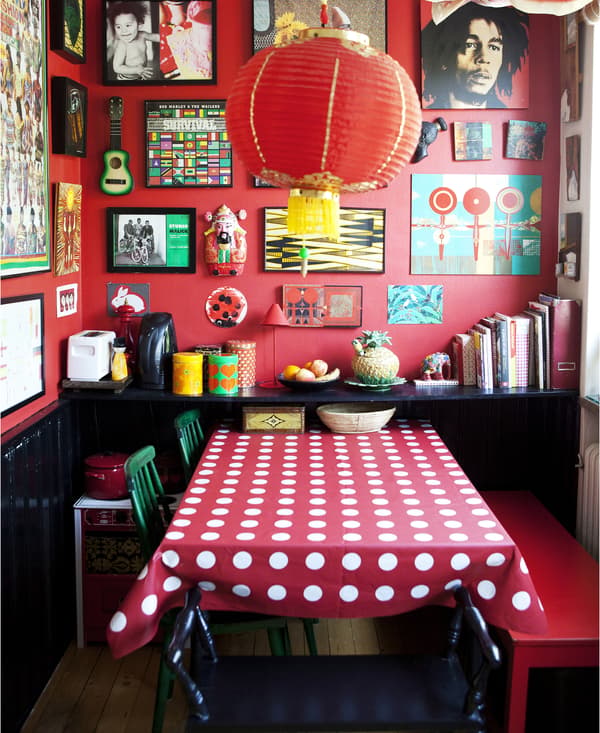Pièce avec murs, nappe et sièges rouge et cadres au mur.