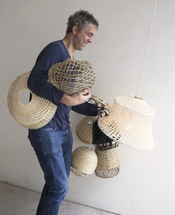 Piet Hein Eek carrying bamboo lampshades.
