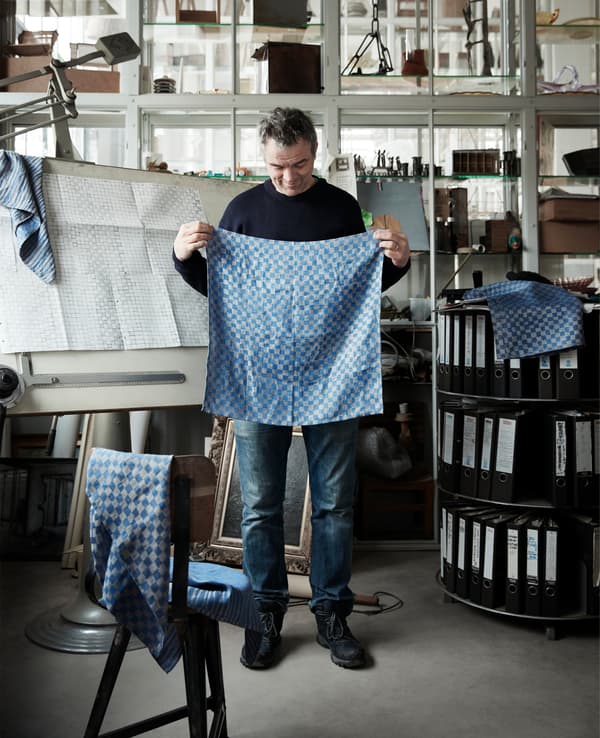 Piet Hein Eek tenant en main des textiles bleus à motifs.