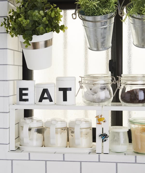 Plants and dry ingredients stored in pots and jars on a shelf insert.