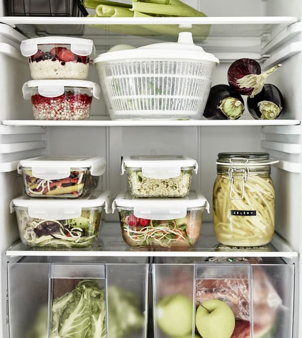 Plastic food containers stacked in a fridge.
