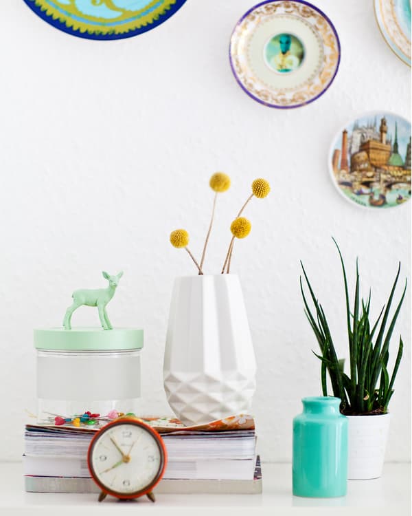 Plates hung on the wall and a vase filled with flowers
