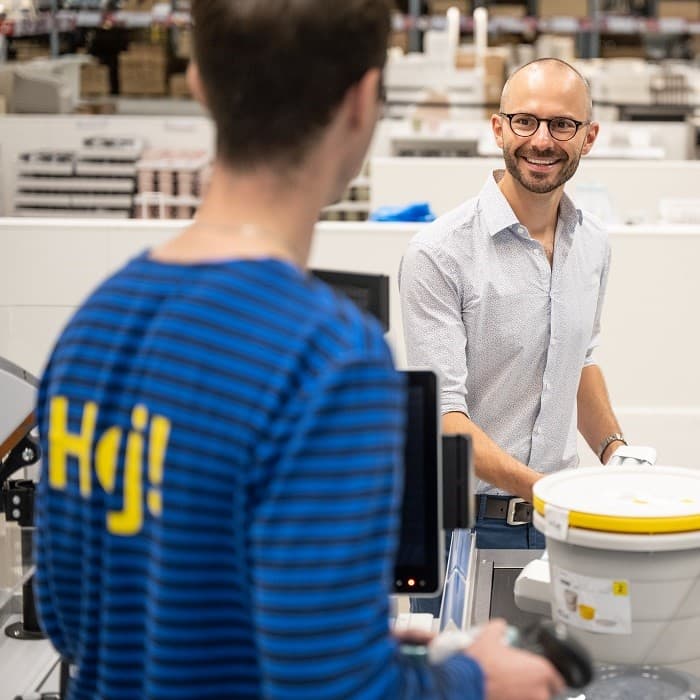 Покупатель выбирает товары и разговаривает с сотрудником IKEA.