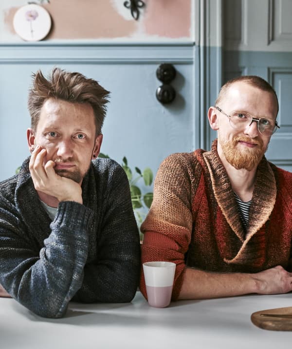 Portrait of two men sitting together at a table.