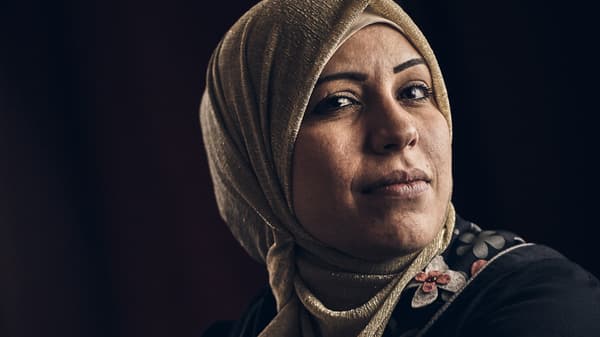 Portrait sur fond noir d’Abeer Almnajed, couturière dans l’ONG Jordan River Foundation.